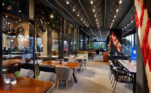 a restaurant with wooden tables and chairs and a lot of windows at The G Hotels Istanbul in Istanbul