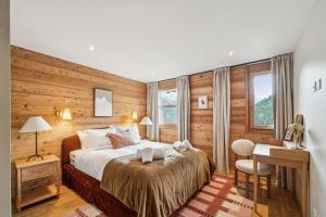 a bedroom with a large bed and a desk and a desk at Chalet SkyLodge by Mrs Miggins in Grimentz