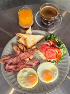 a plate of breakfast food with eggs bacon and toast at เสม็ดทาวน์ Samed Town in Ko Samed