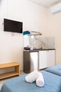 a room with a kitchen and a bed with towels at Penelope - Sea Front Studio in Gouvia