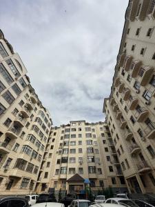 two large buildings with cars parked in front of them at Guest house Пары Резиденты только с ЗАГСом in Samarkand