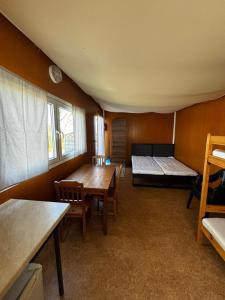a room with a bed and a table in a room at Domki Letniskowe Vertigo Narie in Morąg
