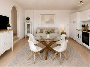 a living room with a table and white chairs at Apartment Simone in Baja Sardinia