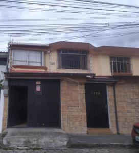 a brick house with two black doors and windows at Suite acogedora en Ibarra in Ibarra