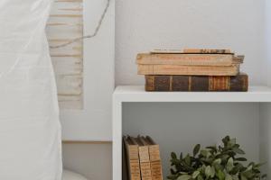 a stack of books sitting on a shelf at Hostal Boutique Es Grop in Port de la Selva +16 photos