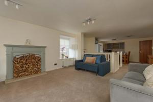 a living room with a fireplace and a blue chair at Cozy 3BR escape near Edinburgh centre in Edinburgh +13 photos