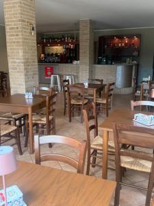ein Restaurant mit Holztischen und -stühlen und einer Bar in der Unterkunft Origami in Magliano Alfieri