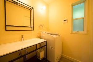 a bathroom with a sink and a mirror and a refrigerator at Resort Villa Takayama in Takayama