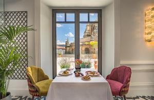 a table in a room with a view of a building at Gran Hotel Claridge Granada - Preferred Hotels & Resorts in Granada