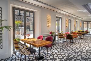 a restaurant with tables and chairs and windows at Gran Hotel Claridge Granada - Preferred Hotels & Resorts in Granada
