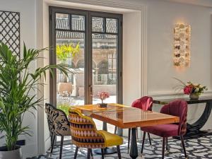 a dining room with a wooden table and chairs at Gran Hotel Claridge Granada - Preferred Hotels & Resorts in Granada +141 photos