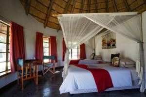 a bedroom with two beds and a canopy at Hlane Royal National Park in Simunye