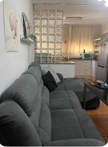 a living room with a large gray couch in front of a kitchen at Villa guiris in Barbate