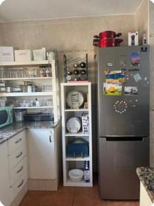 a kitchen with a stainless steel refrigerator and white cabinets at Villa guiris in Barbate +6 photos