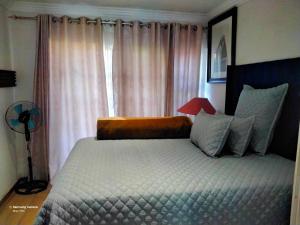 a bedroom with a large bed and a window at Dante Guest house in Alberton