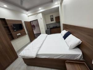 a small bedroom with a bed and a television at Sky Homestay in Noida +5 photos