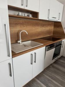 a kitchen with white cabinets and a sink at Apartman David Topoľčany in Topoľčany
