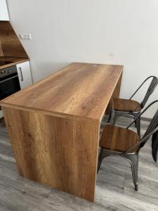 a wooden desk with a chair and a table at Apartman David Topoľčany in Topoľčany