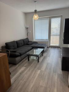 a living room with a black couch and a table at Apartman David Topoľčany in Topoľčany