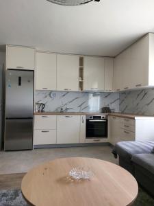 a kitchen with white cabinets and a wooden table at Sofija 1 in Jesenice