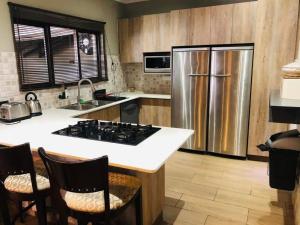 a kitchen with a stove and a refrigerator at B Cubed Lodge in Port Shepstone