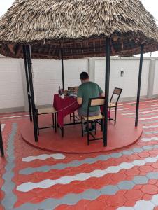 a man sitting at a table in a gazebo at Summit View Retreat in Moshi