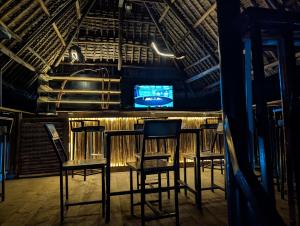 a bar with chairs and a television in a room at Summit View Retreat in Moshi