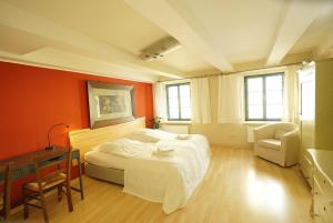 a bedroom with a large bed and a chair at Herberge Zum Sechsten Gebot in Görlitz +12 photos