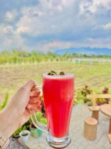 a person holding a red drink in a glass at The Stables by L' Rancho Danilo in Banaba