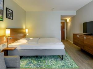 Mercure Stuttgart Sindelfingen an der Messe في شيندلفينجن: غرفة فندق بها سرير وجهاز تلفزيون