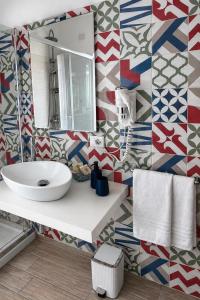 a bathroom with a sink and a mirror at Ciao Ciao Rooms in Letojanni