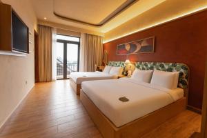 a hotel room with two beds and a television at NiK Hotel Hillside Da Lat in Da Lat