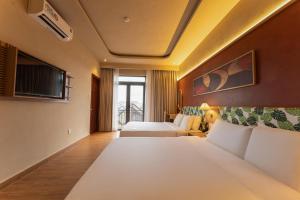 a hotel room with two beds and a tv at NiK Hotel Hillside Da Lat in Da Lat +55 photos