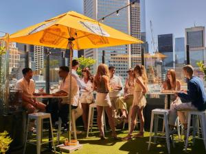 a group of people sitting at tables under an umbrella at Pullman Melbourne City Centre in Melbourne