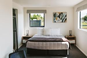 a bedroom with a bed and two windows at Cottages On St Andrews in Havelock North +38 photos