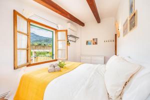 a bedroom with a white bed and a window at Ca n'Antonia in Sóller