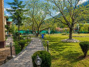 a walkway in a park with trees and grass at Lidder view resort in Muski +13 photos