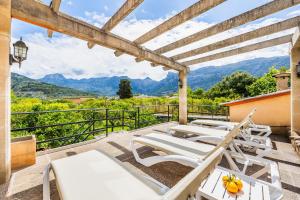 a group of lounge chairs on a patio with a view of mountains at Ca n'Antonia in Sóller