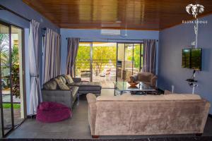 a living room with a couch and a tv at Resta Lodge in Kariba