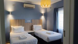 two beds in a room with blue walls at Resta Lodge in Kariba +45 photos