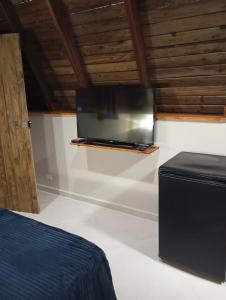 a flat screen tv on a shelf in a room at Chalés FRONT LAKE 2 in Córrego do Bom Jesus
