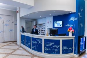 a man standing at a counter in a blue room at Albergo Firenze in Florence