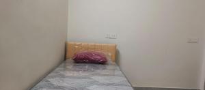 a small bed in a corner of a room at Happy Ladies PG in Kammasandra