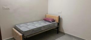 a small bed in a corner of a room at Happy Ladies PG in Kammasandra