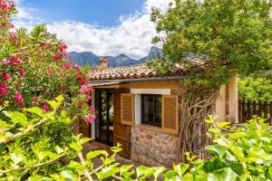 a small house with flowers in the yard at Can Pep in Sóller +15 photos