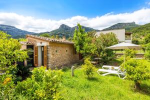 a stone house with a garden and an umbrella at Can Pep in Sóller