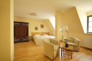 a bedroom with a bed and two chairs and a table at Herberge Zum Sechsten Gebot in Görlitz