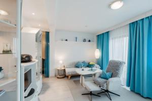 a living room with blue curtains and a table and chairs at Ferienappartement Donautal in Obernzell