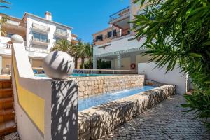 a house with a swimming pool next to a building at SUNSET Apartment in Amoreira