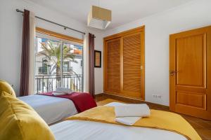 a bedroom with two beds and a large window at SUNSET Apartment in Amoreira +10 photos